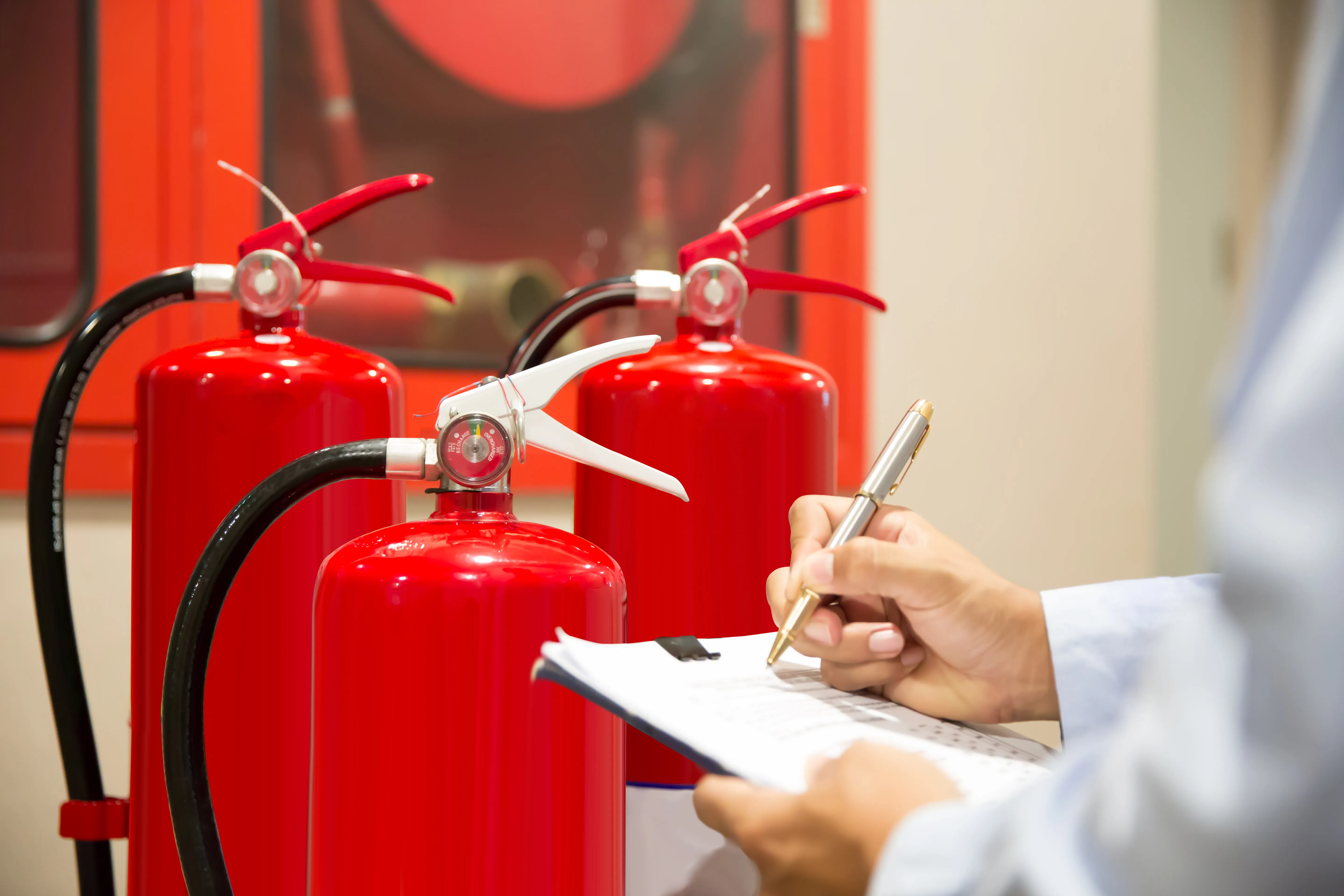 Tecnico che controlla estintori, prevenzione incendi