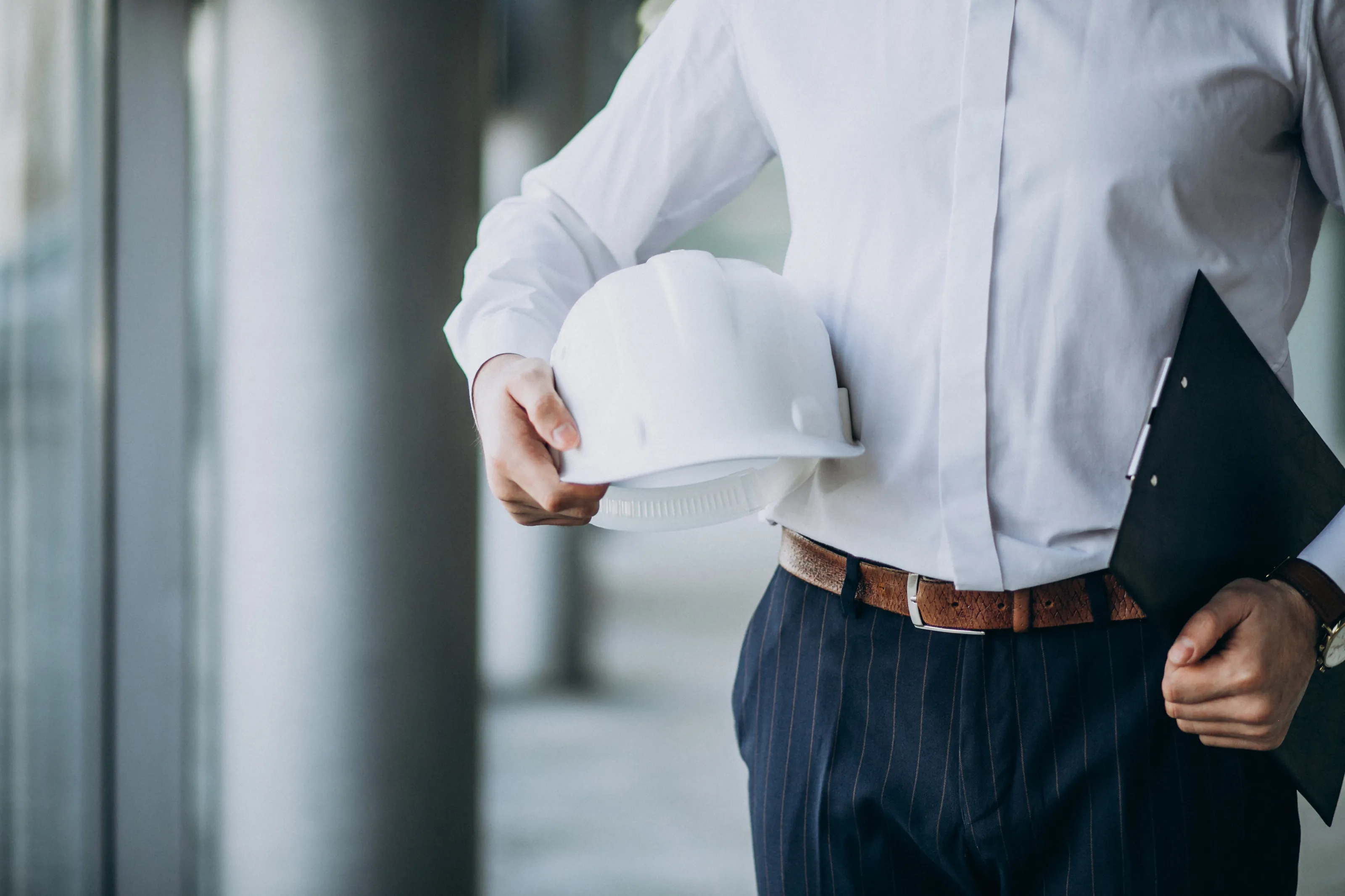 Ingegnere con casco da cantiere e cartella, sicurezza cantieri
